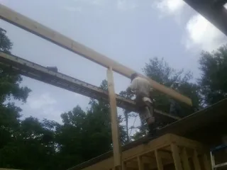 Carpenter setting a ridge beam over a new addition frame — Ice Dam Removal by Roofing Brothers in Kimball