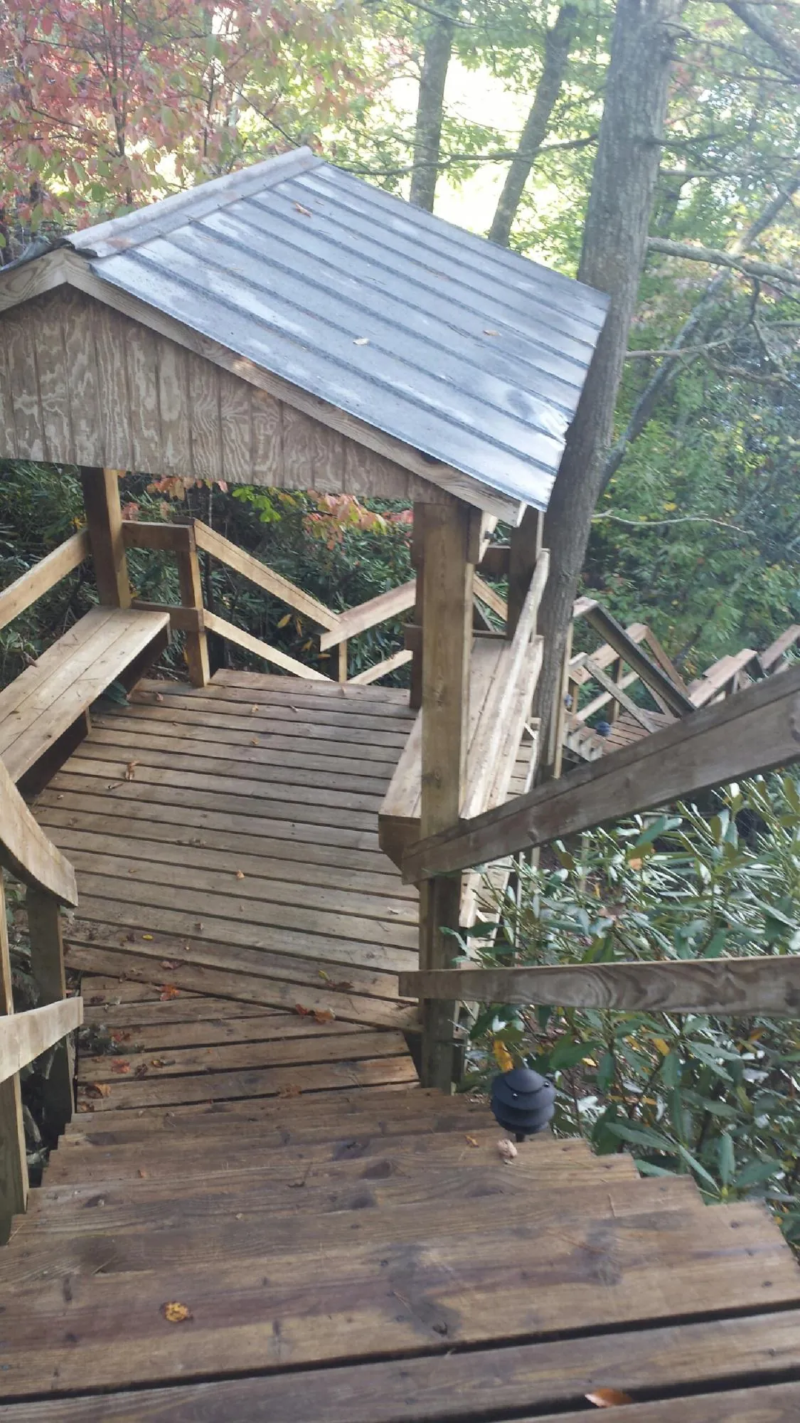 Metal roofed shelter over wooden steps on a wooded walkway — Skylight Repair & Installation work by our crew in Kimball
